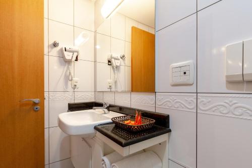 uma casa de banho com um lavatório e um fogo numa tigela em Tri Hotel Executive Caxias em Caxias do Sul