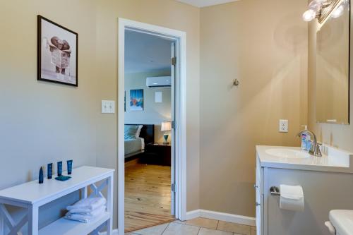 y baño con lavabo y espejo. en Walkable Downtown Apt with Game Room! en Mobile