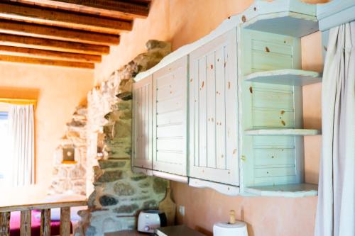 eine Küche mit blauen Schränken und einer Steinmauer in der Unterkunft Chaihoutes stone House into Olive farm in Zia in Ágios Dimítrios