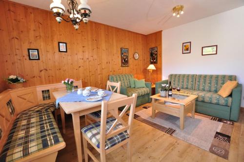 uma sala de estar com uma mesa e um sofá em Bergblick-Seitz em Fischen