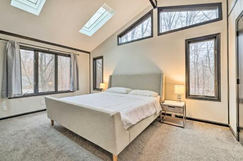 ein Schlafzimmer mit einem großen Bett in einem Zimmer mit Fenstern in der Unterkunft Large Gouldsboro Home with Hot Tub and Game Room in Gouldsboro