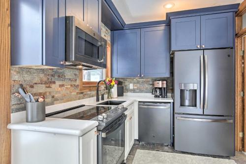 a kitchen with blue cabinets and stainless steel appliances at Cabin on Lake Superior about 11 Mi to Bayfield! in Washburn