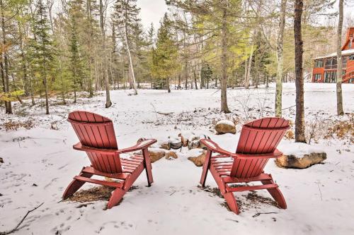 two chairs sitting in the snow in front of a house at Cabin on Lake Superior about 11 Mi to Bayfield! in Washburn