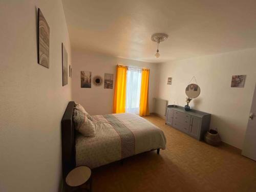 een slaapkamer met een bed, een dressoir en een raam bij Appartement t3 en plein centre-ville châtellerault, in Châtellerault