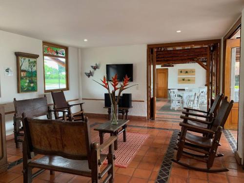 a living room with chairs and a table with a vase of flowers at Finca Hotel Santana in Montenegro