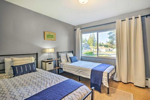 sypialnia z 2 łóżkami i dużym oknem w obiekcie Lakefront Seattle Area House with Private Deck! w mieście Lynnwood