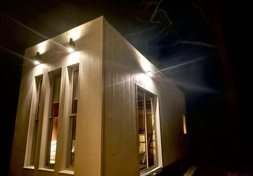 a building with lights on the side of it at night at Tiny House Aire en La Juanita in José Ignacio