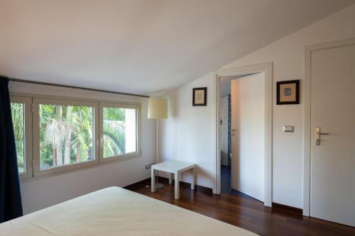 Un dormitorio con una cama y una ventana y una mesa. en Villa Carlino House, en Mascali