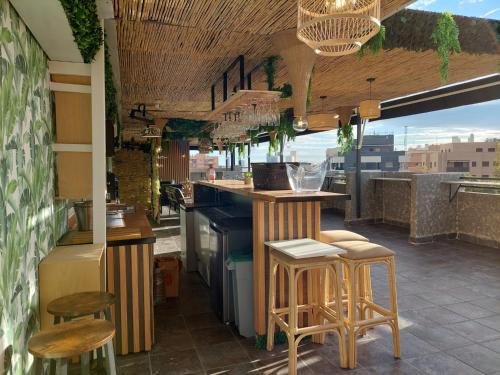 a kitchen with a bar with stools and a view at Hostal GARDEN ROUS in Paiporta