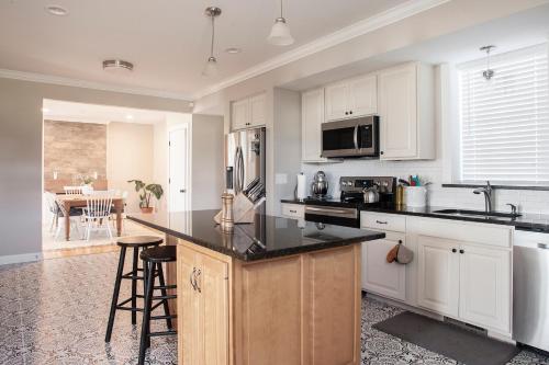 a kitchen with white cabinets and a black counter top at Farmhouse Broad Brook: Comfort & Charm. in East Windsor