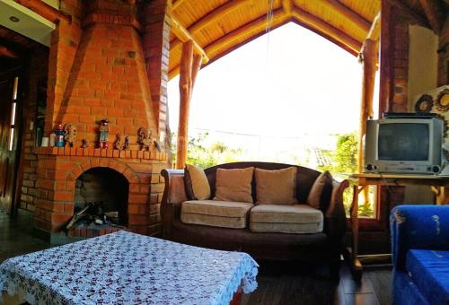 sala de estar con sofá y chimenea en Cabaña Puñushiki kalera Lodge 