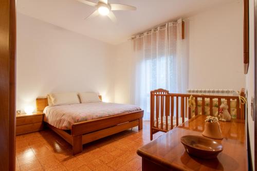 內格拉爾的住宿－Casa di Emma - Verona, Lago di Garda, Valpolicella，一间卧室配有一张床、一张桌子和一张婴儿床。