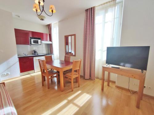 un salon avec une table à manger et une télévision dans l'établissement La Cardabelle, T2, centre Luchon, wifi, casier à ski, ascenseur, 4 personnes, à Luchon