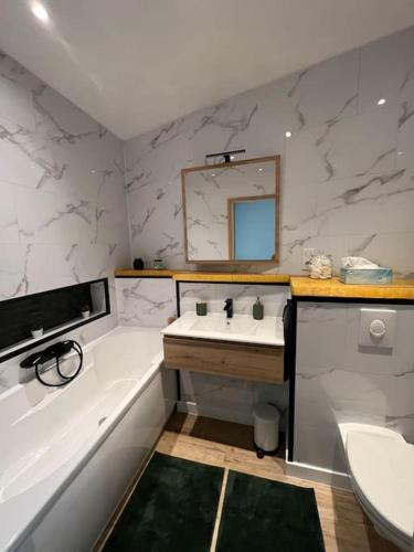 een badkamer met een bad, een wastafel en een bad bij La cabane verte - une nuit pour deux in Verneuil-sur-Vienne