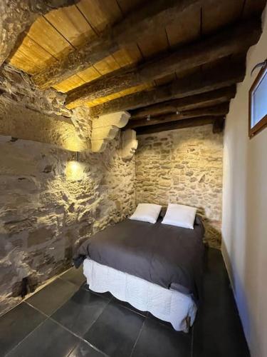 une chambre avec un lit dans un mur de pierre dans l'établissement 