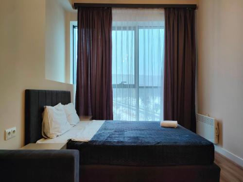 a bedroom with a bed and a large window at Tsaghkadzor Kechi Apartment 136 in Tsaghkadzor