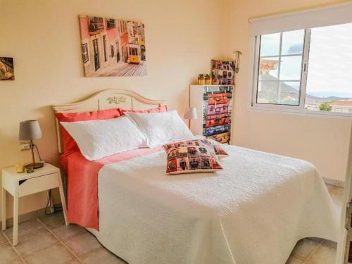 a bedroom with a large bed with red sheets and a window at Lovely Apartment in Tenerife South in Chayofa