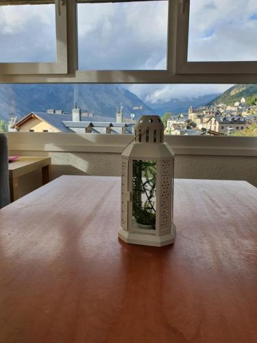a clock on a table in front of a window at Rincón de Cerler in Cerler