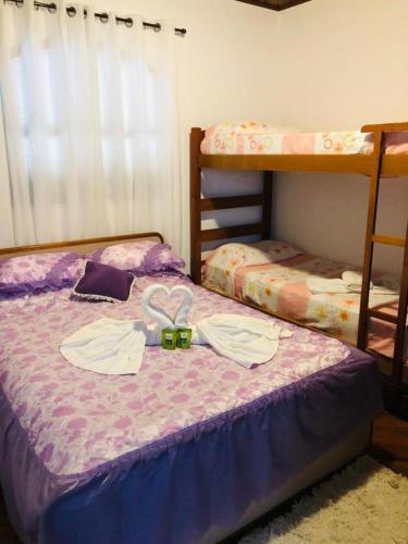 1 dormitorio con 2 literas y 1 cama con toallas en Chalé de Férias, en Campos do Jordão
