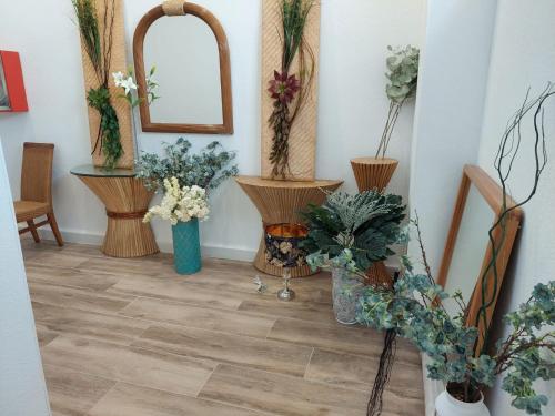 a room with vases of flowers and a mirror at Hostal GARDEN ROUS in Paiporta