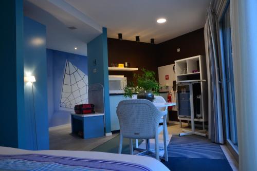 une chambre avec un lit et une cuisine avec une table dans l'établissement Bleus Nuit, à Lierneux