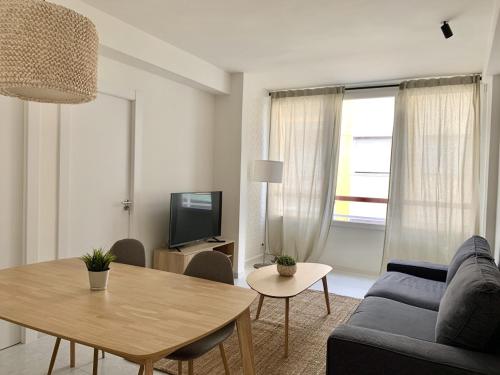 a living room with a blue couch and a table at Apartamento junto a Estación Ave · 3 dormitorios in Granada