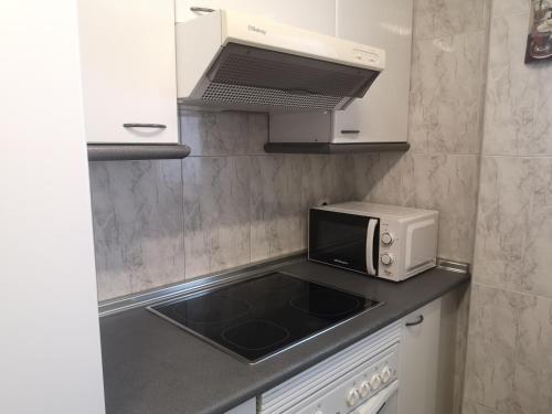 una pequeña cocina con microondas y fregadero en LC Escultor Moreto - PARKING GRATIS, en Zaragoza