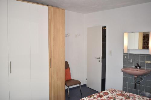 a bedroom with a bed and a sink and a chair at Zentrum Lai (458 Kr) in Lenzerheide