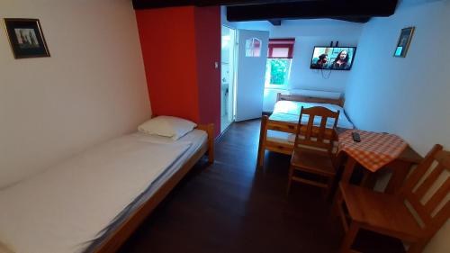 a small room with a bed and a table and chairs at Różana Karczma in Kruszyn