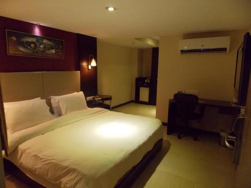a bedroom with a large bed in a hotel room at Lords Plaza Surat in Surat