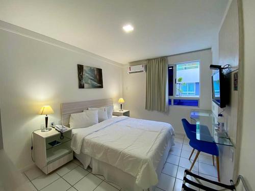 a bedroom with a bed and a desk and a television at H Ponta Negra Beach in Natal