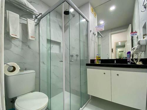 een badkamer met een toilet en een glazen douche bij H Ponta Negra Beach in Natal