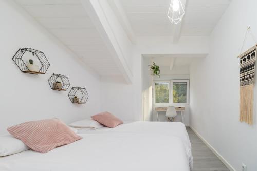 a white bedroom with a bed and a window at Casa Camino del Dobra, Centro de Cantabria in Viérnoles