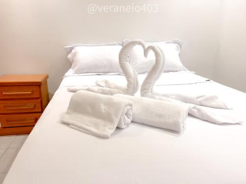 Deux cygnes se posent sur un lit avec des serviettes dans l'établissement Apartamento frente mar c/ar P/ 6 hóspedes, à São Vicente
