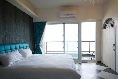 a bedroom with a bed and a large window at Whitecaps B&B in Yanliau
