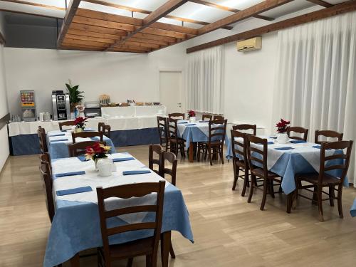 un comedor con mesas y sillas con flores. en Hotel Friuli en Cervignano del Friuli
