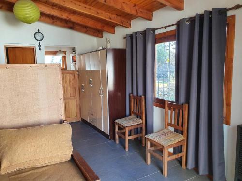 um quarto com duas cadeiras e uma cama e uma janela em Mono Belgrano1 em San Carlos de Bariloche