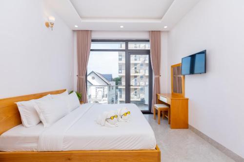 a bedroom with a bed and a tv and a window at Minh Phước Villa 12 Kim Ngân in Vung Tau