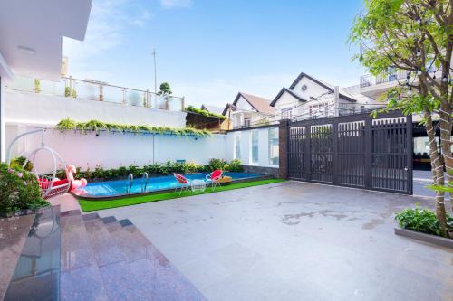 a backyard with a swimming pool and a fence at Minh Phước Villa 12 Kim Ngân in Vung Tau