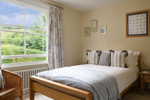 a bedroom with a bed and a large window at Pentre Bach in Llansantffraid Glan Conwy