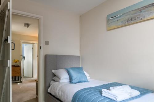 een bed met blauwe en witte kussens in een slaapkamer bij Tan y Celyn in Llangelynin