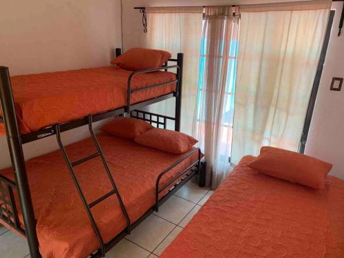 a room with two bunk beds and a window at Casa 2 a 5 min del Irtra in Retalhuleu