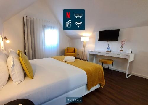 a hotel room with a bed and a desk at Seasons Porto-Gaia by MyStay in Vila Nova de Gaia