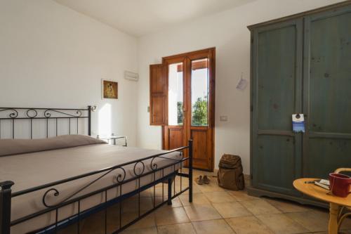 Schlafzimmer mit einem Bett und einer Holztür in der Unterkunft Agriturismo La Facenda in Albinia