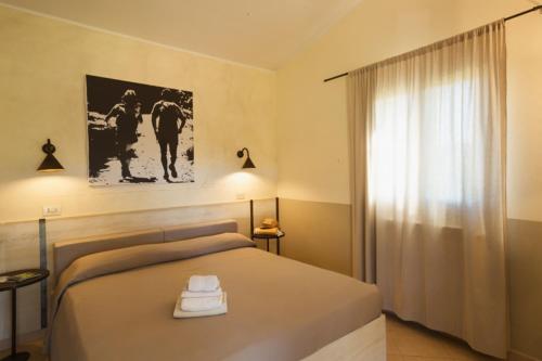 a bedroom with a large bed and a window at Agriturismo La Facenda in Albinia