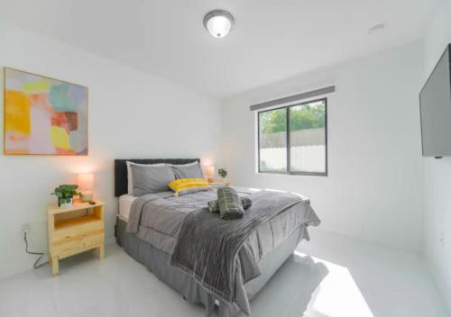 um quarto branco com uma cama e uma janela em Fantastic Brand New 3BD Duplex In Miami em Miami