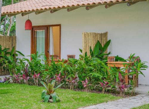 a house with a garden in front of it at Pousada Vila Mangaba in Arraial d'Ajuda