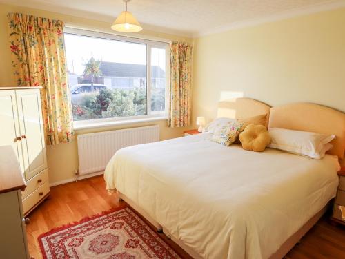 a bedroom with a bed with a teddy bear on it at Acre View in Mablethorpe