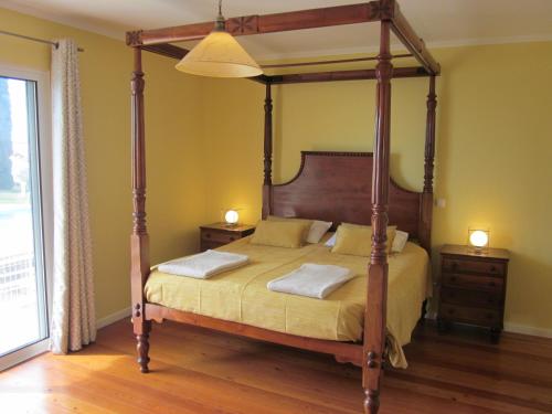 a bedroom with a four poster bed with two night stands at Villa Hansen in Garajau - Cristo Rei in Caniço