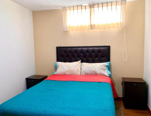 1 dormitorio con 1 cama con manta azul y roja en Arum Qurpawasi Hospedaje, en Cabanaconde